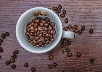 Cup with coffee beans on a brown tree