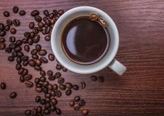 Cup with coffee on a tree with coffee beans