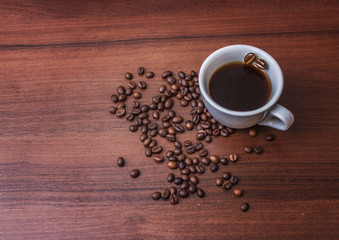 Cup with coffee on a tree with coffee beans