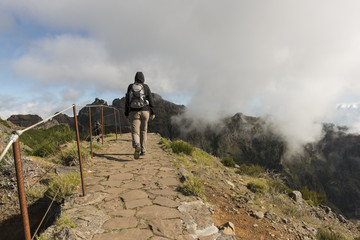 Turista caminando en un sendero de piedra en las montañas de Madeira, Portugal