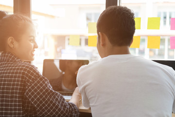 Fototapeta premium student sitting in room smiling and talking in cafe, start up business people meeting and using laptop in co working space