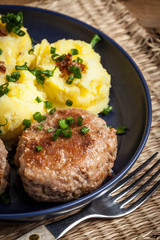 Meatballs served with boiled potatoes on a plate.