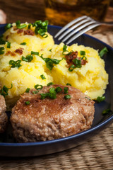 Meatballs served with boiled potatoes on a plate.