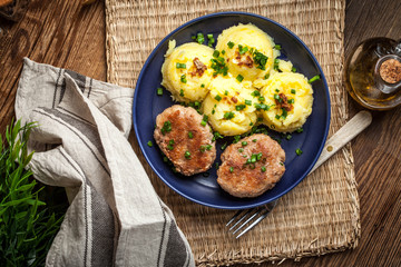 Meatballs served with boiled potatoes on a plate.