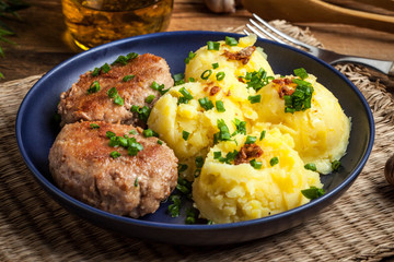 Meatballs served with boiled potatoes on a plate.