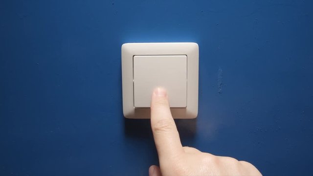 Light is Off - Human hand switch off a button on a blue wall