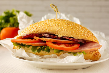 Sandwich with ham, sausage and tomato