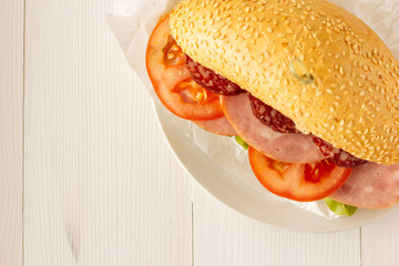 Sandwich with ham, sausage and tomato top view