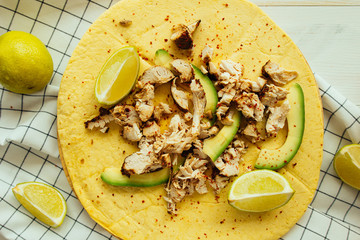 Tortilla with chicken, avocado and lime top view