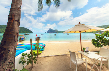 Thailand,Phi Phi Don serenity, summer beach holidays - two beach lounge chairs at the sand beach under umbrella and palm tree, romantic set up concept