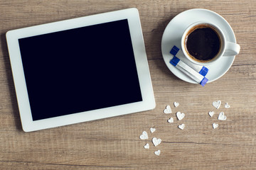 tablet with coffee cup on the wood texture.