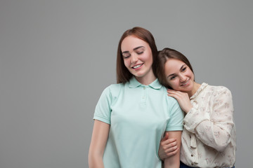 Two women hugs together, studio photo shoot