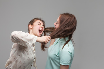 Fototapeta premium Two girls fighting, women quarrel