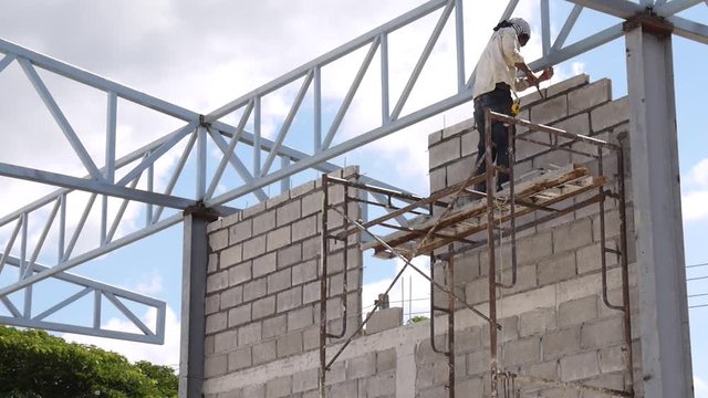 Wall construction worker build concrete wall by cement block.
