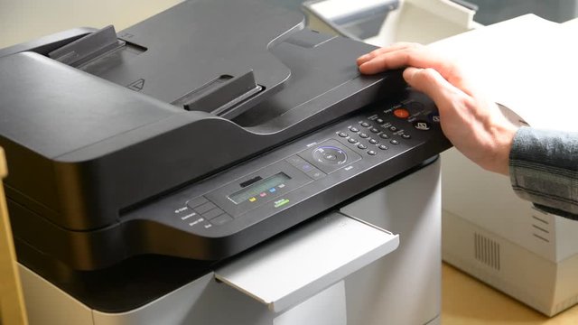 Male hand printing document on printer or fax or scanner, then retrieving paper sheet
