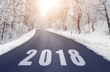 Empty road in forest in winter with 2018 text