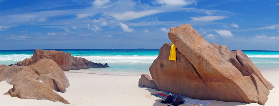 Strandpanorama mit schattigem Platz hinter Felsen am Meer
