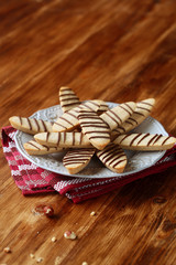 Hazelnut Long Cookies decorated with chocolate treads, on grey plate, on wooden background.
