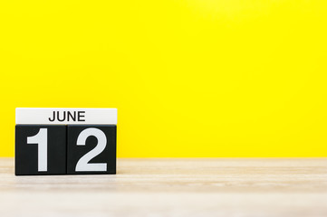 June 12th. Day 12 of month, calendar on yellow background. Summer day. Empty space for text