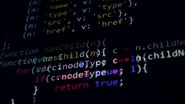 4K. Computer code on display screens in a dark.