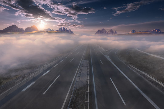 Empty freeway through clouds at idyllic sunrise