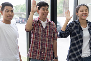 young asian start up business man and woman standing and smiling, college student raise hands in classroom