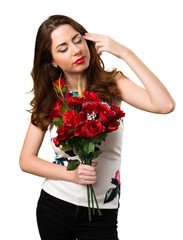 Beautiful young girl holding flowers making suicide gesture