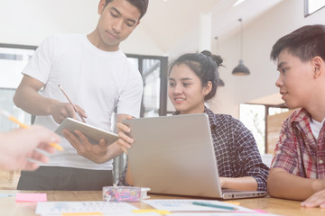 Fototapeta premium startup young successful team on meeting in modern office interior brainstorming, make a business plan, working on laptop computer and tablet with financial and marketing graph and chart