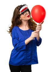 Beautiful young girl holding a red balloon with crazy glasses