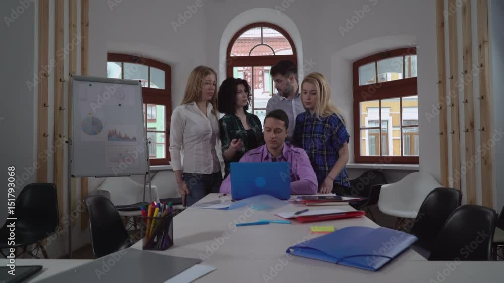 Poster business team discussing something on screen laptop. young casual creative co workers pointing on co
