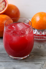 Red orange juice. Grey wooden background. Top view.
