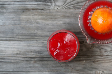 Red orange juice. Grey wooden background. Top view.