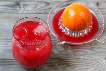 Red orange juice. Grey wooden background. Top view.