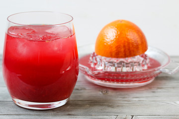 Red orange juice. Grey wooden background. Top view.