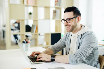 Happy businessman working online in office