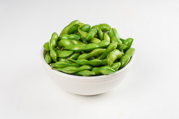 Green beans in white bowl on a white background