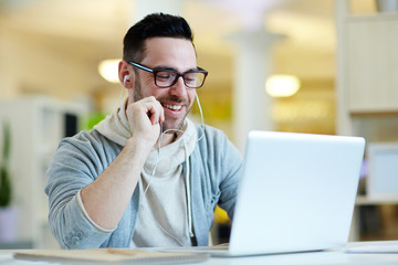 Businessman with earphones enjoying break in front of laptop