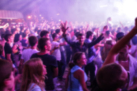 Blurry night club dj party people enjoy of music dancing sound with colorful light. club night light dj party Ibiza club. With Smoke Machine and lights. Dark background.