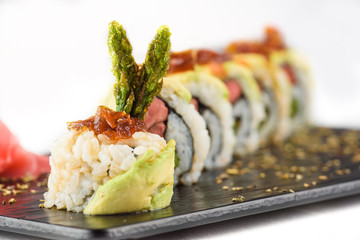 Closeup of rolls and sushi served on a black stone plate