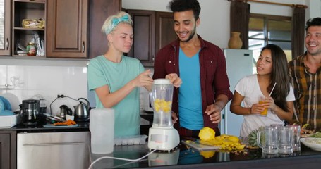 Young Man Chopping Pineapple, Woman Use Blender Prepare Healthy Smoothie People Group Talking Two Couples In Kitchen Cooking Together Slow Motion 60