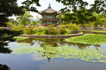 Fototapeta na wymiar Seoul. The Gyeongbokgung Palace. Pavilion Hyangwonjeong in a beautiful park landscape with a lotus pond on a summer day