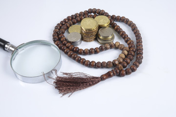 Rosary and coins on white background. Islamic business concept.