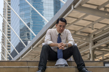 Businessman sitting on the sidewalk in the city. And are stressed