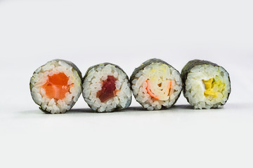 Closeup four peaces of sushi maki rolls with different fresh tasty ingredients
