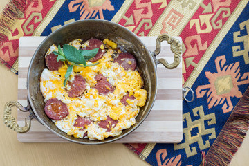 Fried eggs with pepperoni and fresh mint leaves