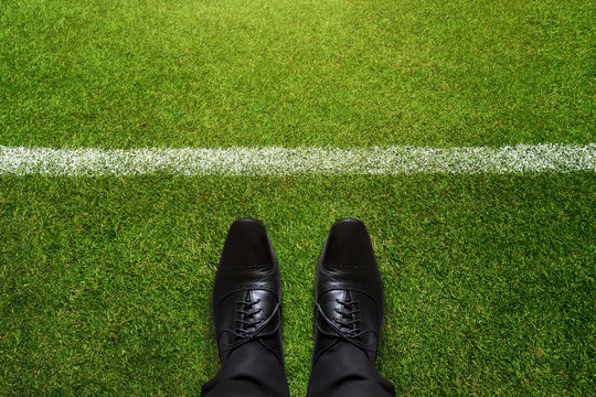 Business Challenge concept, Black formal shoes in soccer field