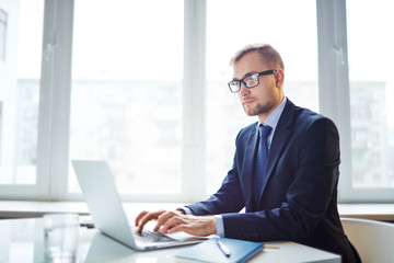 Busy salesman or broker working online in office