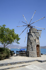 Fototapeta na wymiar Old windmill on a beach. Elounda, Crete, Greece