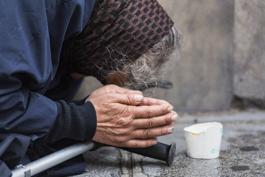 Homeless elderly woman refugee  in a street