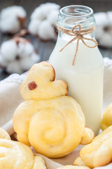 Homemade sweet buns made in bunny shape served with bottle of milk in a wooden box, vertical, closeup